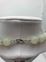 A GREEN JADE & BLACK TOURMALINE & RUBY JADE NECKLACE with beads on a mannequin.