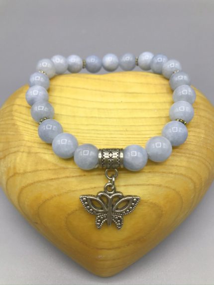 Un braccialetto con un ciondolo farfalla e perle di giada blu.