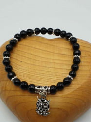 A black tourmaline bracelet with an owl pendant.