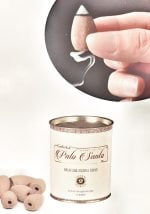 A person is holding a jar with PALO SANTO GOLOKA INCENSE IN CONES inside.