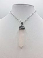 Una PUNTA DI QUARZO ROSA con una pietra di quarzo rosa e una catena d'argento.