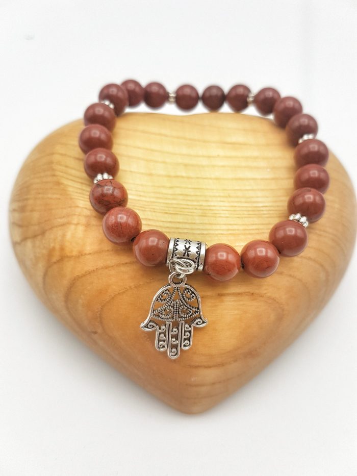 Un BRACCIALE DIASPRO ROSSO con un ciondolo argento a forma di mano di Fatima.