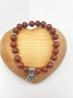 Un BRACCIALE DIASPRO ROSSO con un CIONDOLO MANO DI FATIMA.