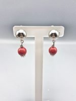 Un paio di orecchini a clip con corallo rosso.