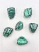 Cinque pietre MALACHITE BURATTATA su una superficie bianca.
