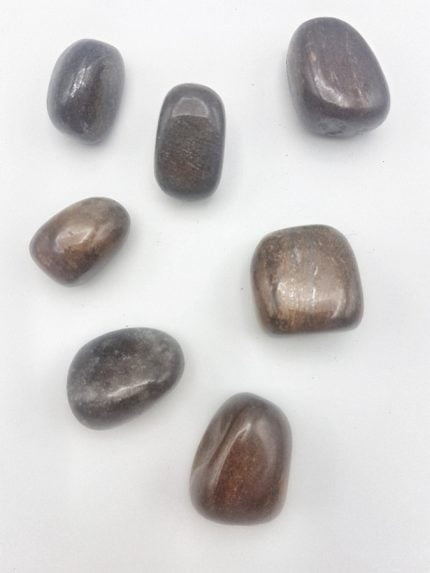 Un gruppo di pietre di BRONZITE BURATTATA su una superficie bianca.
