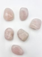 Cinque pietre di QUARZO ROSA BURATTATO su fondo bianco.
