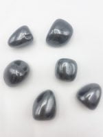 A group of grey stones, similar to TUMBLED HEMATOCYTE, arranged in a TUMBLED HEMATITE pattern on a white surface.
