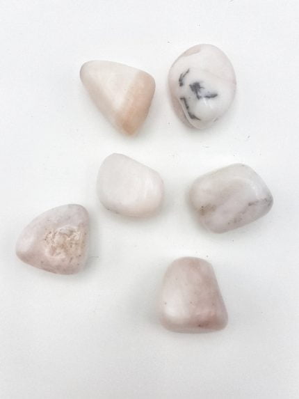 Una collezione di pietre Opale Rosa Burattato su fondo bianco.