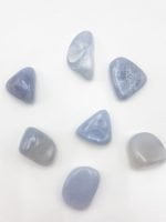 A group of TUMBLED CHALCEDONY stones on a white surface, showing the beauty and uniqueness of TUMBLED CHALCEDONY.