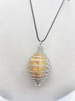 Una collana SPIRALE con una pietra gialla racchiusa in una gabbia metallica GABBIA IN ACCIAIO PER PIETRE.