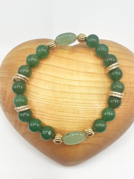 A GOLDEN GREEN AVENTURINE BRACELET on a golden wooden heart.
