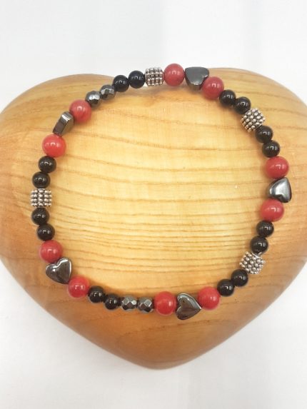 A BRACCIALE CORALLO, EMATITE E ONICE NERA con perline nere e rosse.