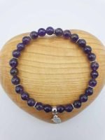 An AMETHYST BRACELET with a silver charm.