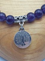 Un BRACCIALE DI AMETISTA CON ALBERO DELLA VITA con un charm argentato.