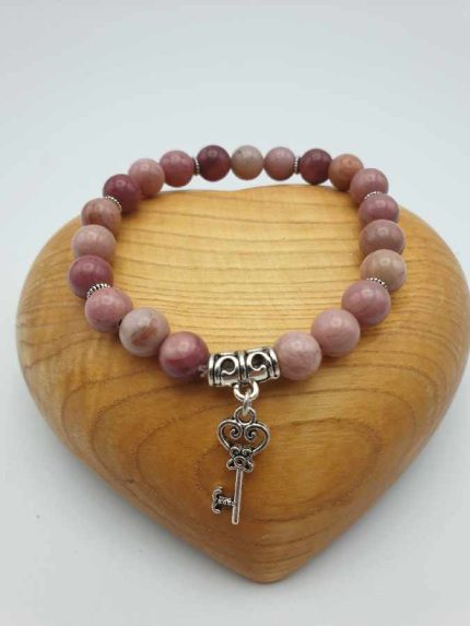 A RHODONITE BRACELET WITH A KEY PENDANT.