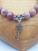 UN BRACCIALE DI RODONITE CON CIONDOLO CHIAVE.