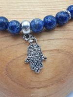 Un BRACCIALE DI LAPISLAZZULI con un ciondolo hamsa d'argento.