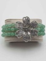 A GREEN AVENTURINE AND RHINESTONE FLOWER BRACELET with a bright flower.