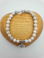A HOWLITE AND TREE OF LIFE BRACELET with a white stone and a silver pendant.