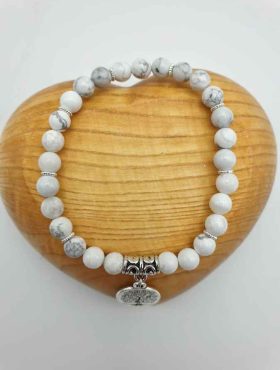 A HOWLITE AND TREE OF LIFE BRACELET with a white stone and a silver pendant.
