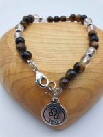 A MEN'S BRACELET WITH ROCK CRYSTAL, TIGER'S EYE AND LION PENDANT with tiger's eye pearl and lion pendant.