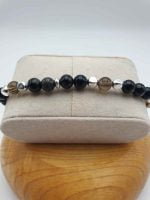 A black and silver bracelet with pearls and a Capricorn pendant.