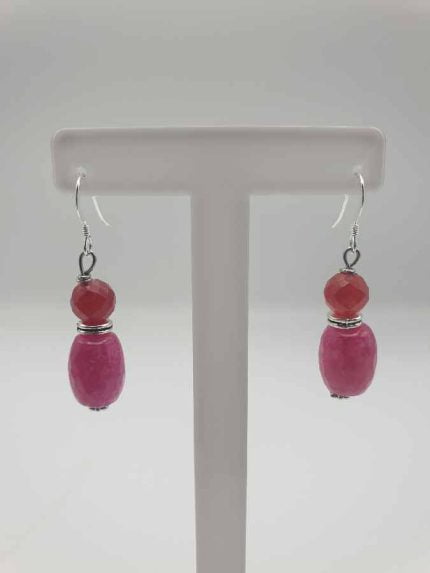 Pair of pink and coral earrings with ruby jade on display.