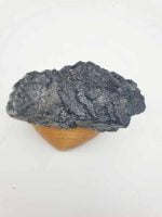 A TORMALINA NERA SCHORL Pezzo alto 11 CM, una roccia nera, appoggiata su una base di legno.