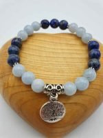 A SILVER AQUAMARINE AND LAPIS LAZULI BRACELET featuring a tree of life pendant and blue lapis lazuli, accented with aquamarine.