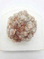 A white ARAGONITE ROSETTE crystal on top of a white plate.
