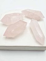 Four BITERMINATED ROSE QUARTZ SPIKES quartz tips on white plate.
