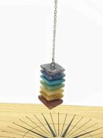 PENDULUM SEVEN CHAKRAS PYRAMID BALANCE stack of colored stones representing the seven chakras for achieving balance.