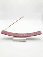 A RED SOAPSTONE INCENSE BURNER with a red incense stick.