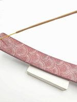 A pink stick of RED SOAPSTONE INCENSE BURNER.