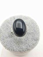 AN OVAL BLACK ONYX RING.