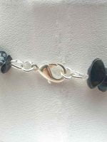 A black beaded bracelet with silver clasp, MEN'S OBSIDIAN NECKLACE SNOWFLAKE CHIPS GIVES BALANCE, which gives balance.