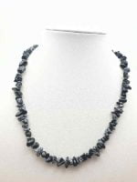 A MANNEQUIN WEARING A MEN'S OBSIDIAN SNOWFLAKE CHIPS NECKLACE GIVES BALANCE brings balance to men's fashion.