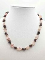 A ROSE QUARTZ AND GARNET NECKLACE on a mannequin.