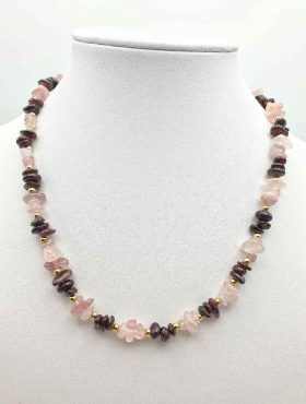 A ROSE QUARTZ AND GARNET NECKLACE on a mannequin.