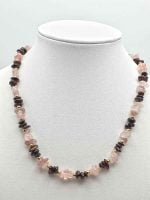 A ROSE QUARTZ AND GARNET NECKLACE on a mannequin.