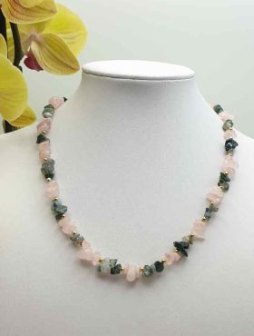 A ROSE QUARTZ AND MUSKY AGATE CHIPS NECKLACE with pink and green stones on a mannequin decorated with rose quartz and musky agate chips.