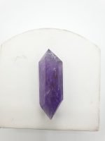 Biterminated amethyst tips placed on a white table.