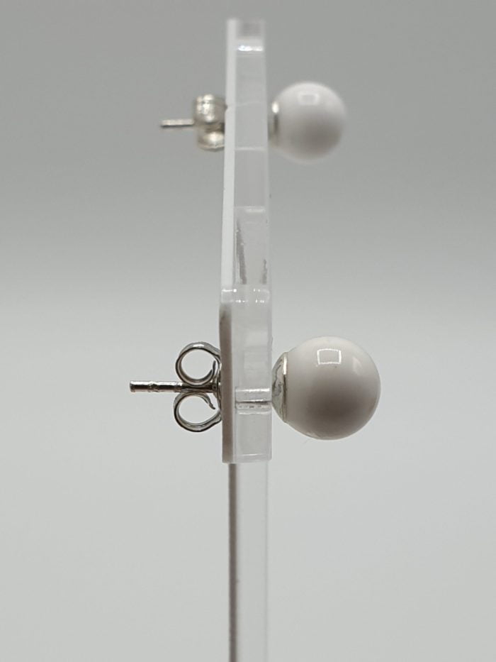 A pair of Earrings with White Agate 6 mm in Silver stud earrings on support, made with White Agate in silver.