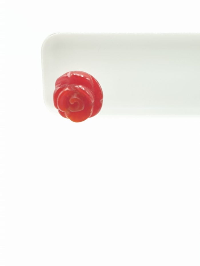 Piatto bianco con orecchino ORECCHINI CORALLO A FORMA DI ROSA IN ARGENTO a forma di rosa rossa realizzato in argento.