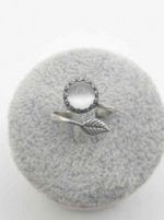 Un anello ANELLO CON OCCHIO DI GATTO BIANCO E FOGLIA ARGENTO argentato con una foglia.
