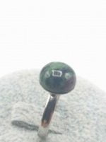 Un ANELLO CON ZOISITE RUBINO TONDO d'argento con una pietra verde e viola.