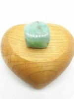 Una pietra CRISOPRASIO BURATTATO in una scatola di legno a forma di cuore.