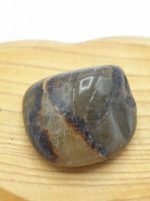 Una pietra SEPTARIA BURATTATA appoggiata su un piano di legno.