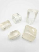 Four pieces of YELLOW ULEXITE TUMBLED on a white surface.